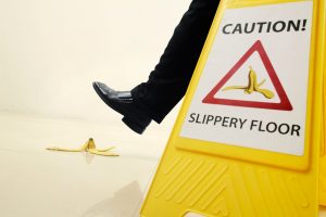 Businessman walking with Caution sign beside slippery floor sign with a banana